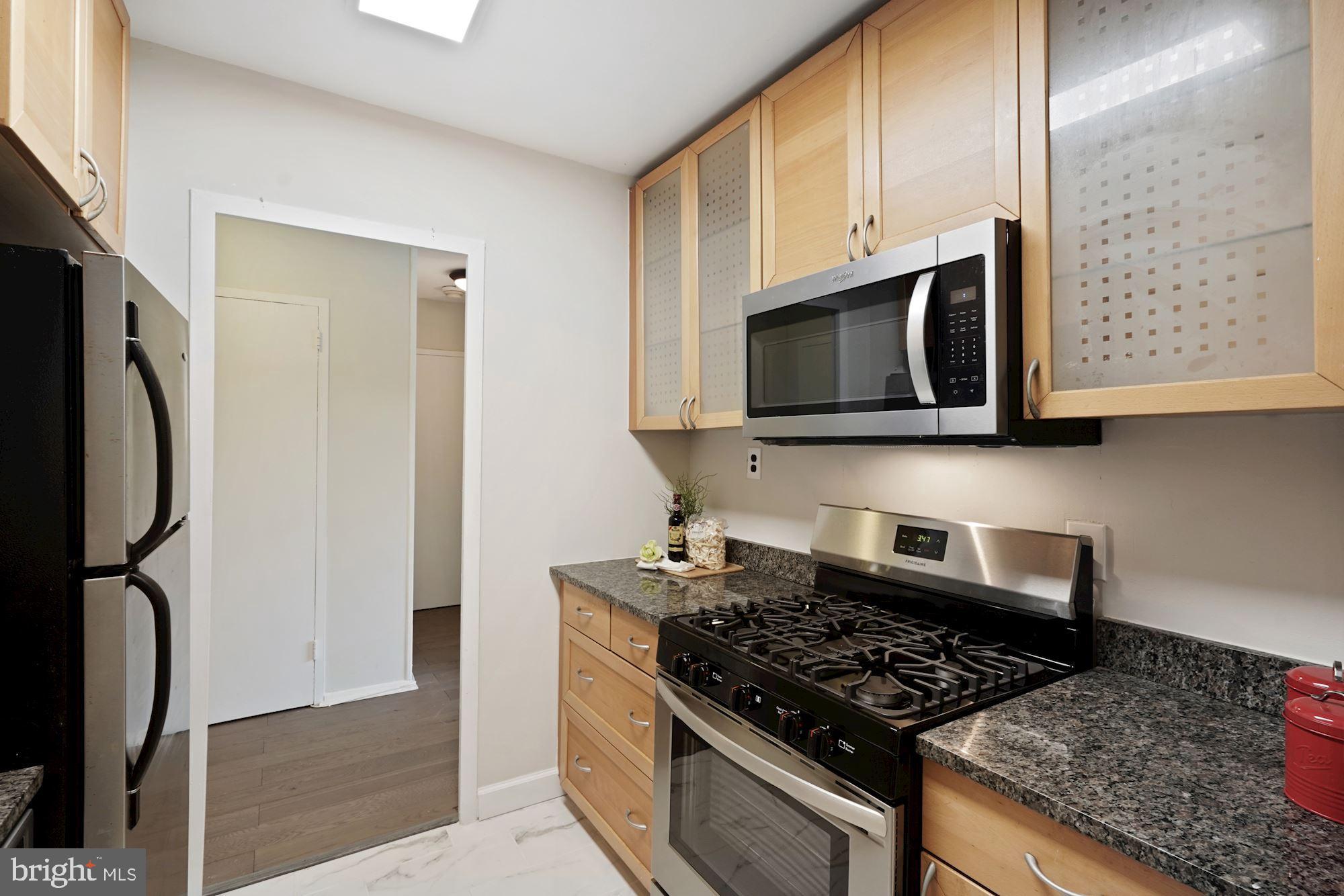 4000 Tunlaw Road Northwest, Unit 1123 Washington, DC 20007 - Photo 16 of 31 a kitchen with stainless steel appliances granite countertop a stove and a microwave