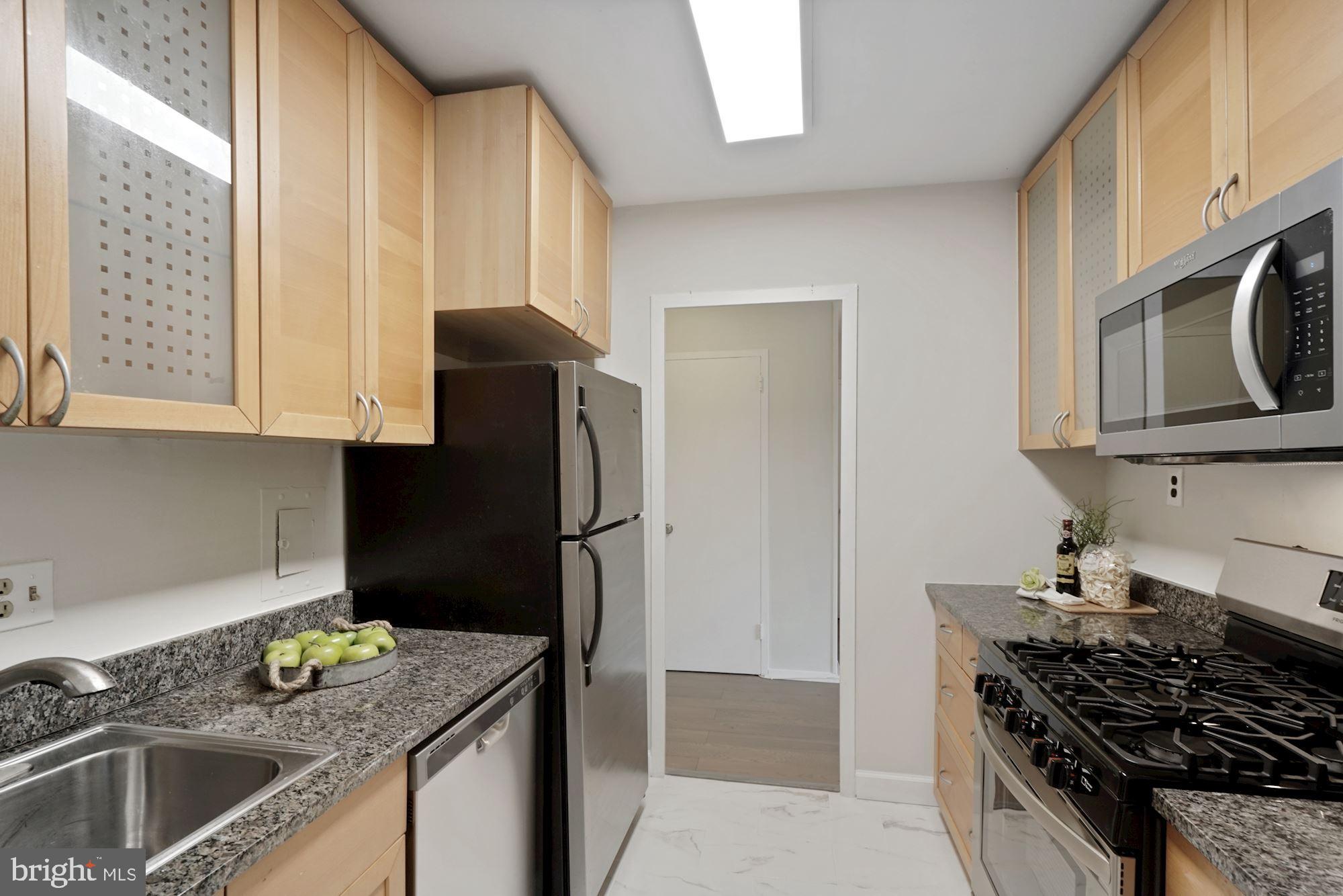 4000 Tunlaw Road Northwest, Unit 1123 Washington, DC 20007 - Photo 17 of 31 a kitchen with stainless steel appliances granite countertop a sink stove and refrigerator