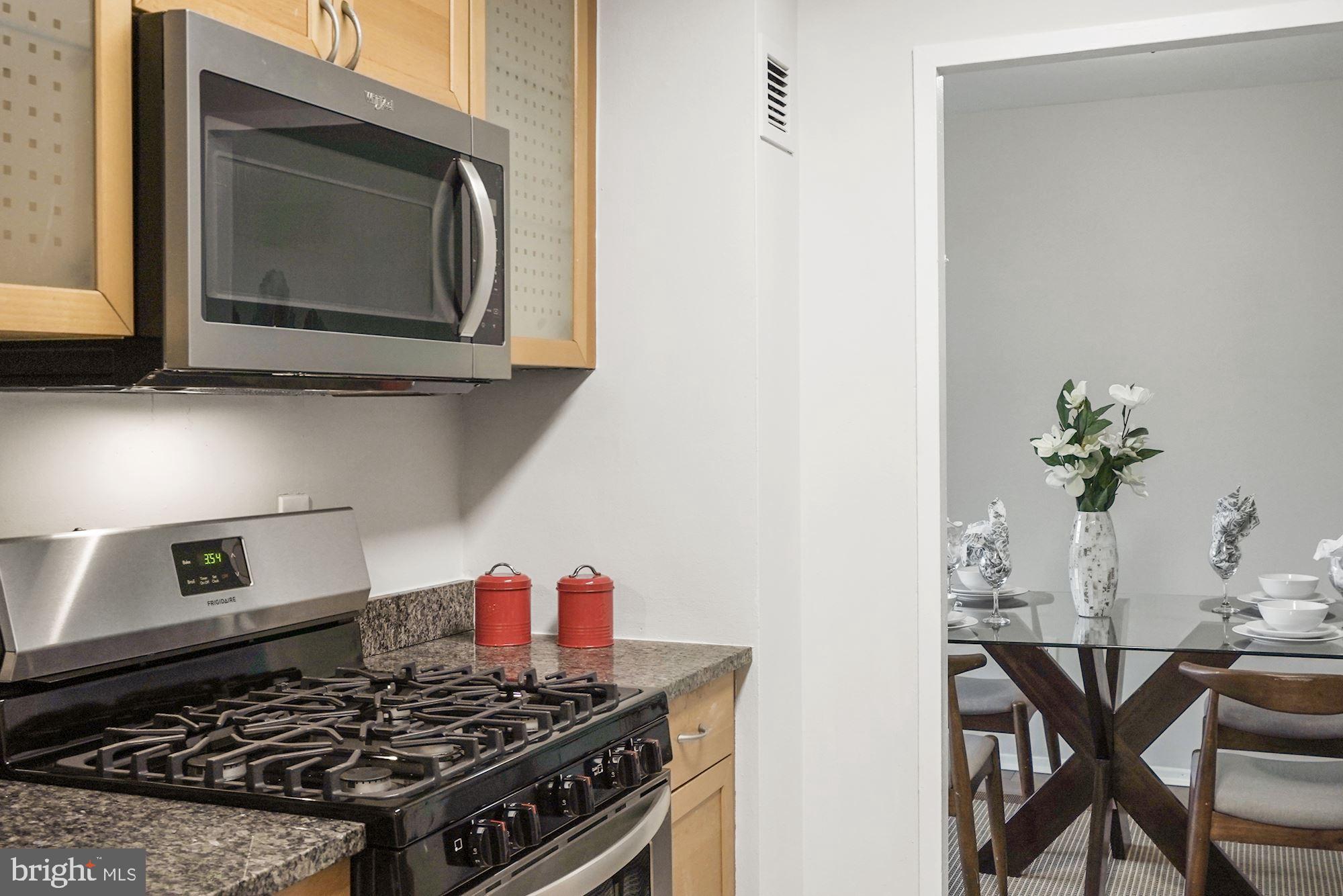4000 Tunlaw Road Northwest, Unit 1123 Washington, DC 20007 - Photo 18 of 31 a kitchen with a stove and a microwave