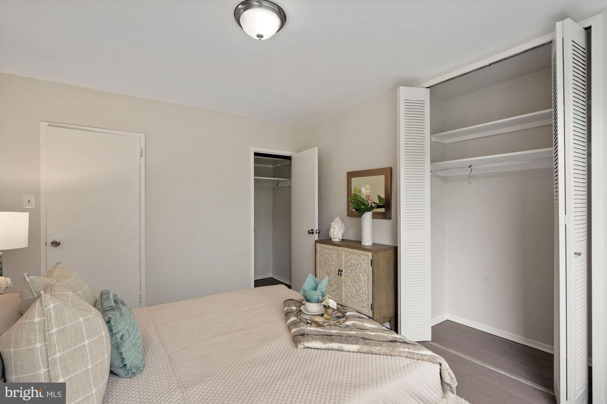 4000 Tunlaw Road Northwest, Unit 1123 Washington, DC 20007 - Photo 19 of 31 a bedroom with a bed and lamp