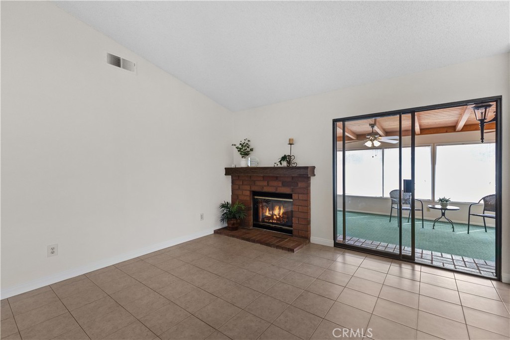 1157 West Orchard Street Rialto, CA 92376 - Photo 13 of 38 a view of an empty room with a fireplace and a floor to ceiling window