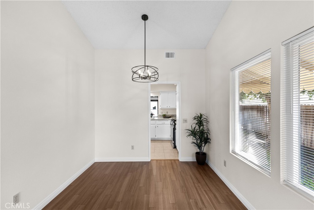 1157 West Orchard Street Rialto, CA 92376 - Photo 8 of 38 a view of an empty room with a window and wooden floor