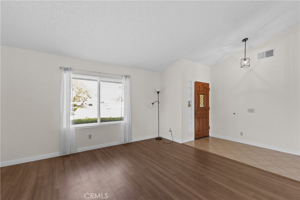 1157 West Orchard Street Rialto, CA 92376 - Photo 9 of 38 an empty room with wooden floor and windows