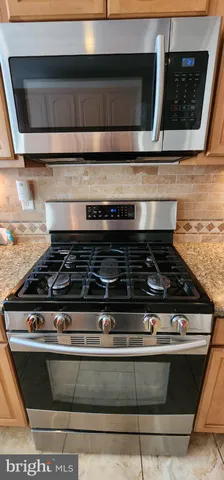 a stove top oven sitting inside of a kitchen