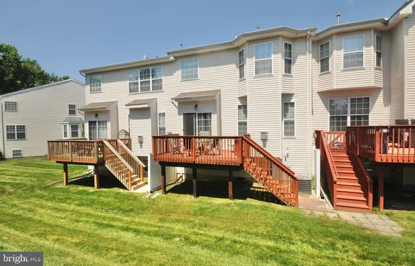 a view of a house with wooden deck and a slide