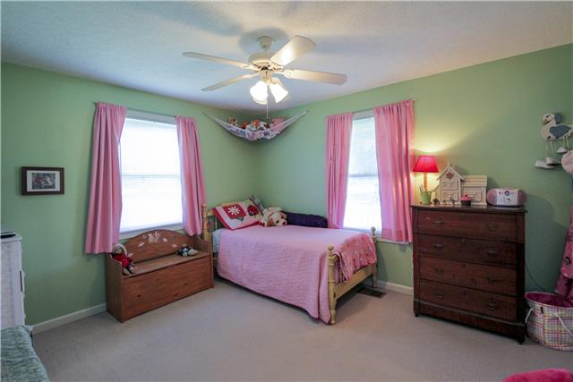 3612 Mahlon Moore Road Spring Hill, TN 37174 - Photo 16 of 20 a bedroom with a bed and a chandelier