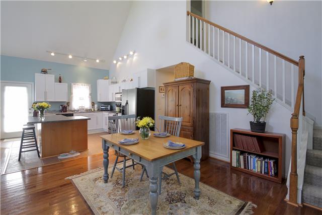 3612 Mahlon Moore Road Spring Hill, TN 37174 - Photo 4 of 20 a open kitchen with stainless steel appliances kitchen island granite countertop a refrigerator a stove a sink dishwasher and a dining table with wooden floor