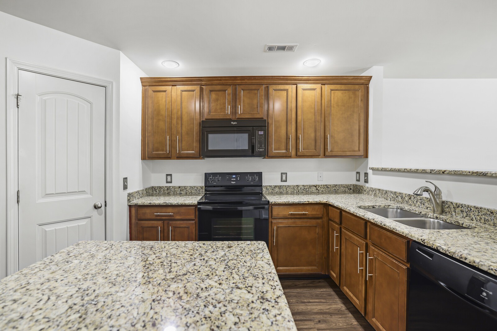 3946 Hoggett Ford Road Hermitage, TN 37076 - Photo 10 of 28 a kitchen with stainless steel appliances granite countertop a stove top oven a sink dishwasher and a refrigerator with wooden floor