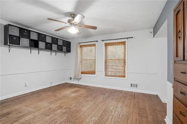 a view of an empty room with a window and wooden floor