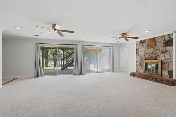 a view of an empty room with a fireplace and a window