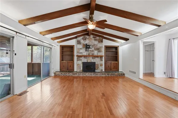 a view of a livingroom with wooden floor a fireplace and window