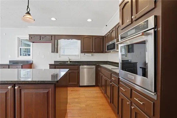 a kitchen with granite countertop a sink stove and refrigerator