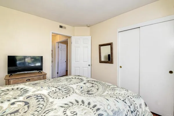 a bedroom with a bed and a flat screen tv in it