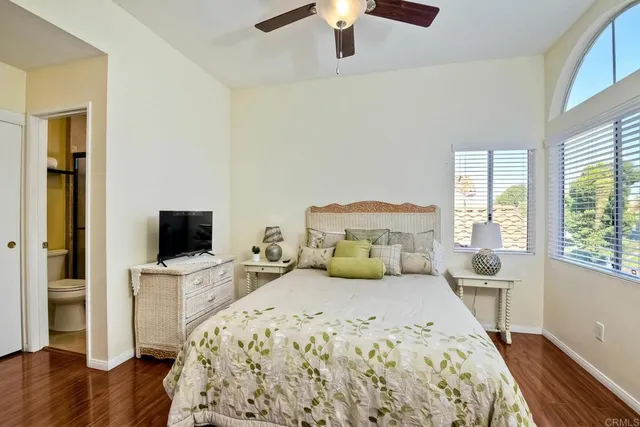 a bedroom with a bed and a flat tv screen on the dresser
