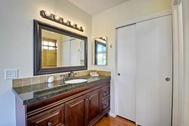 a bathroom with a granite countertop sink and a mirror