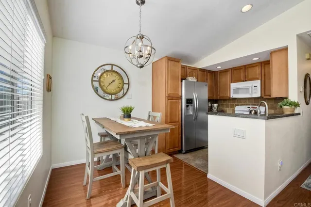 a view of a dining room with furniture a kitchen and chandelier