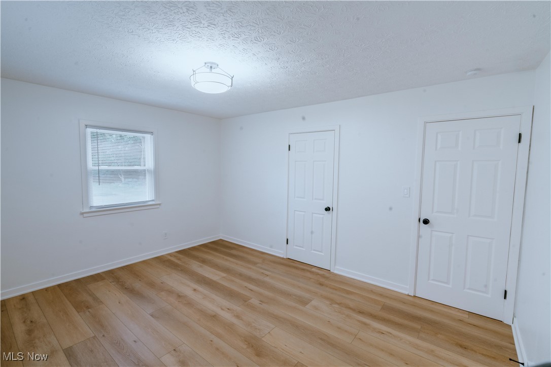 3525 Mayfair Road Akron, OH 44312 - Photo 24 of 31 Unfurnished bedroom featuring light wood-type flooring and a textured ceiling