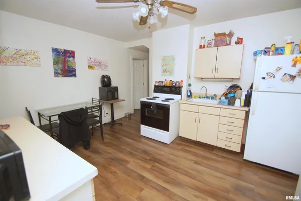 a kitchen with a sink a stove a refrigerator and white cabinets