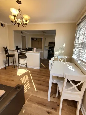 a view of a dining room with furniture wooden floor and chandelier