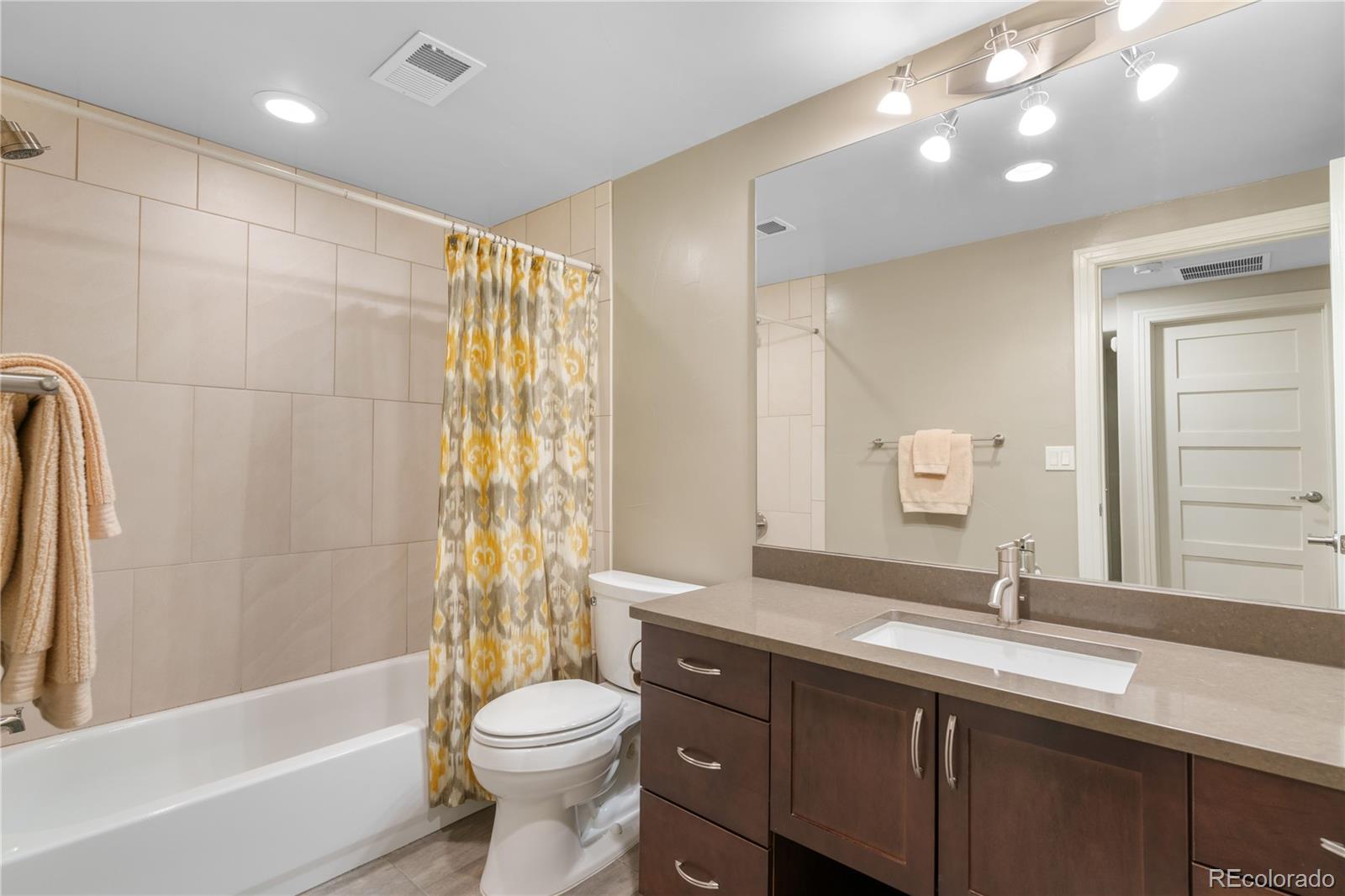 2334 Lowell Boulevard Denver, CO 80211 - Photo 27 of 42 a bathroom with a double vanity sink toilet and shower