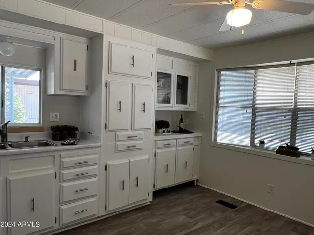 a kitchen with white cabinets and window