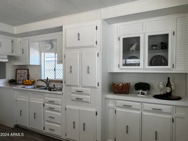 a kitchen with white cabinets and sink