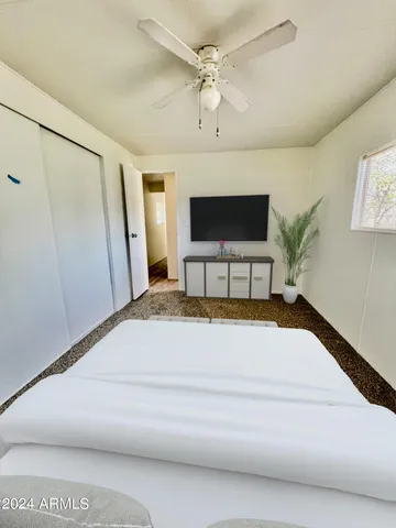 a spacious bedroom with a bed and a flat screen tv