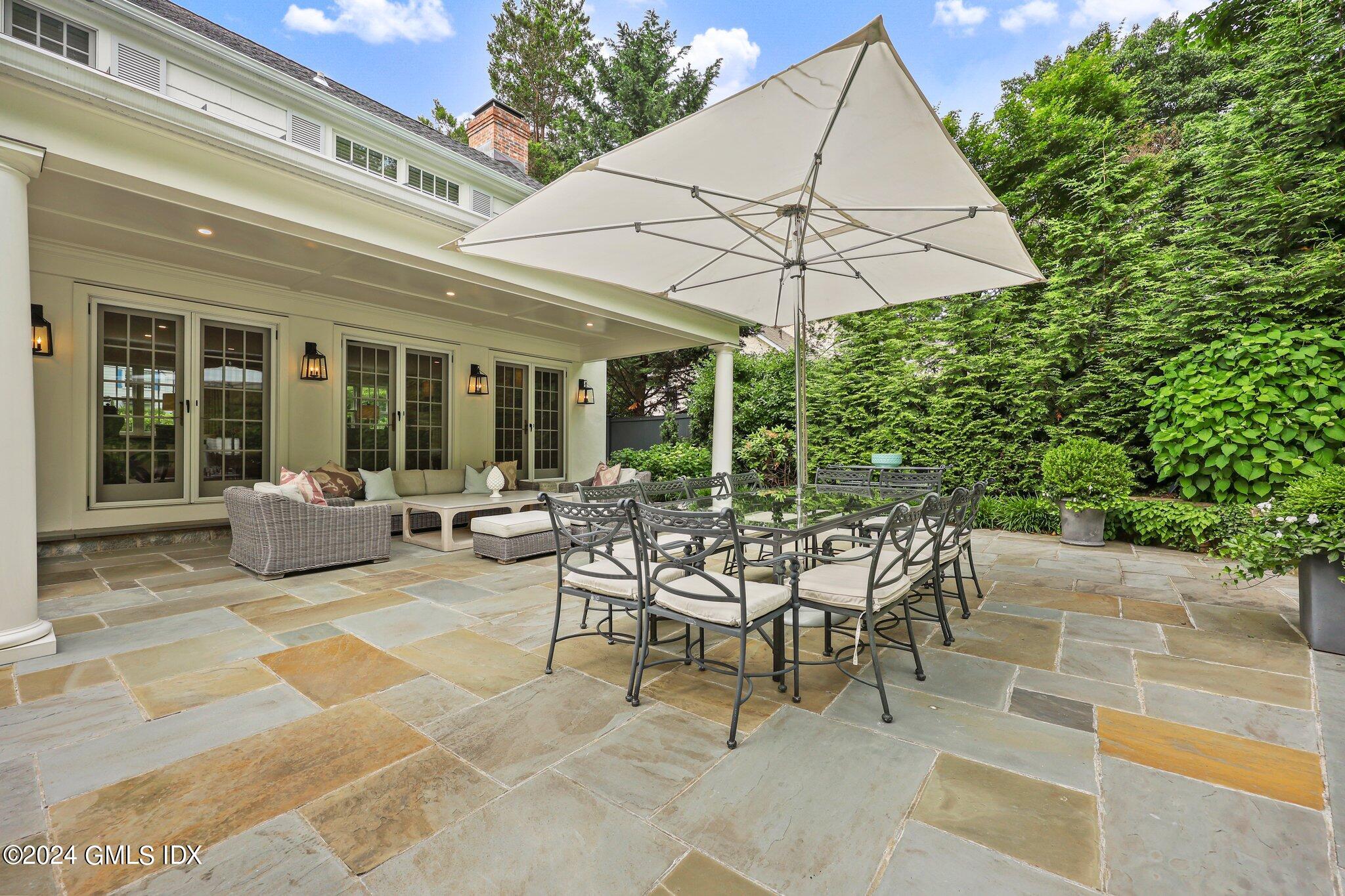 16 Wesskum Wood Road Riverside, CT 06878 - Photo 31 of 37 a view of a patio with a table and chairs under an umbrella