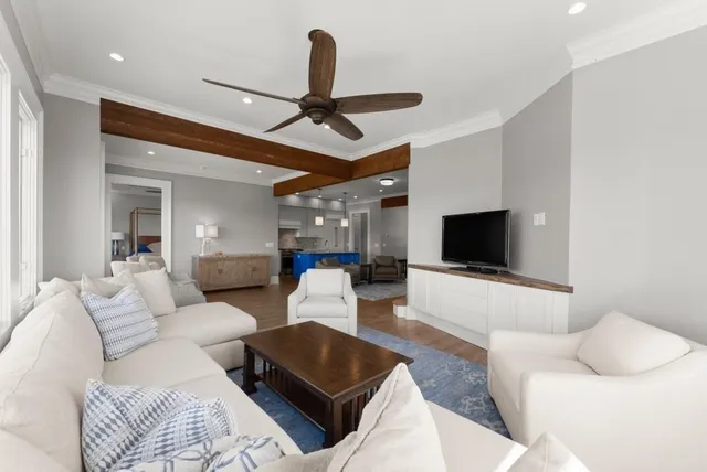 an empty room with wooden floor and a ceiling fan
