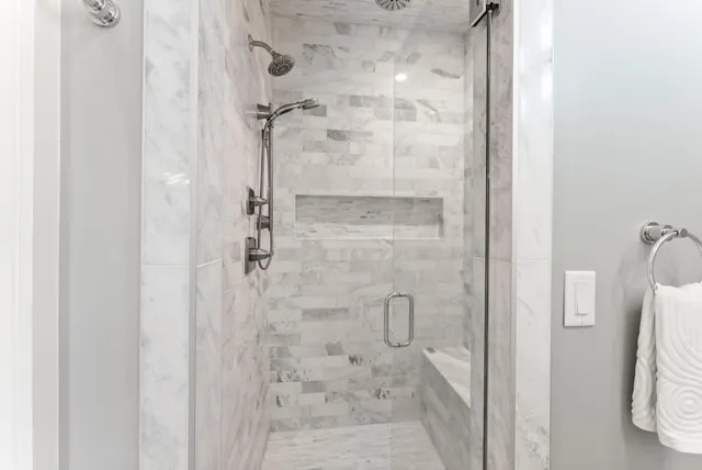 a bedroom with a large bed and a chandelier