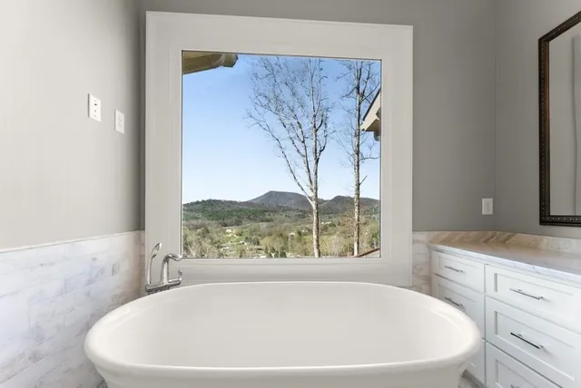 a large bed sitting in a bedroom next to a window