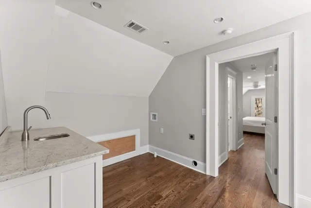 a kitchen with stainless steel appliances granite countertop a sink cabinets and wooden floor
