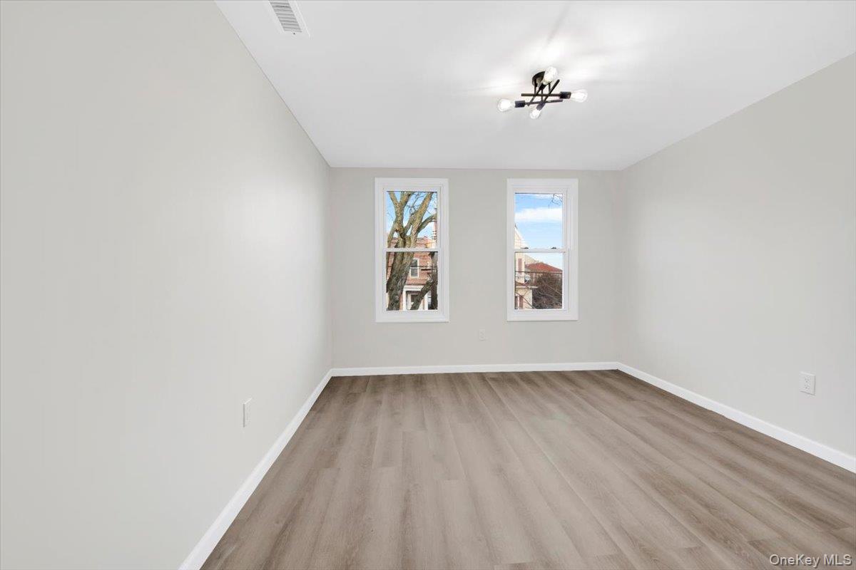 1625 Overing Street Bronx, NY 10461 - Photo 12 of 25 an empty room with a window and wooden floor