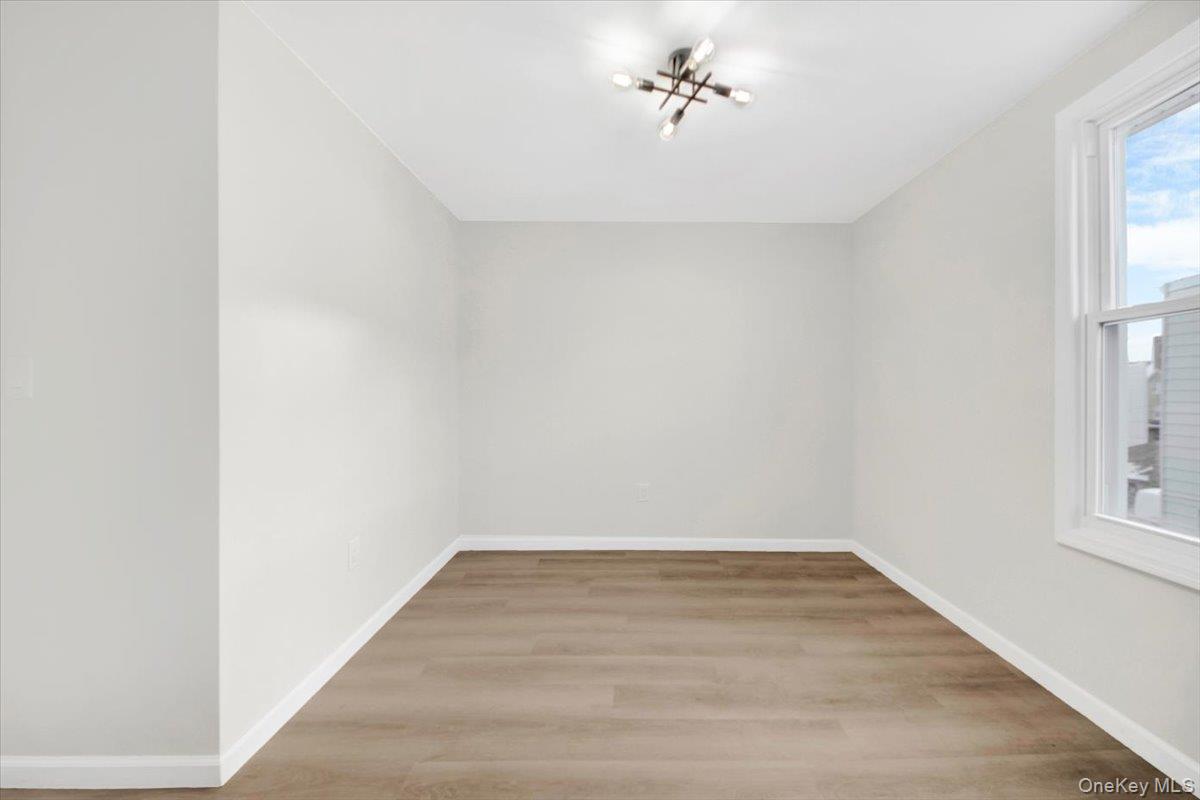 1625 Overing Street Bronx, NY 10461 - Photo 15 of 25 a view of an empty room with a window and wooden floor