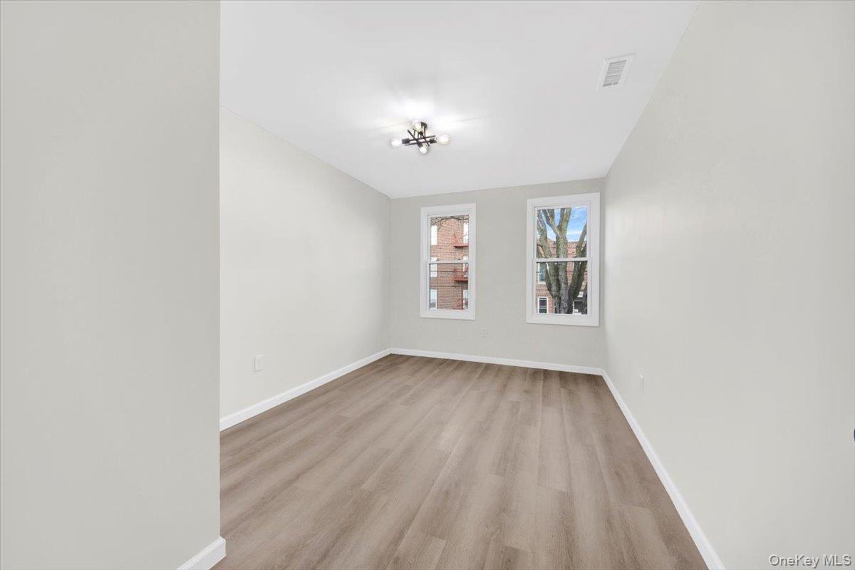 1625 Overing Street Bronx, NY 10461 - Photo 10 of 25 an empty room with windows and ceiling fan