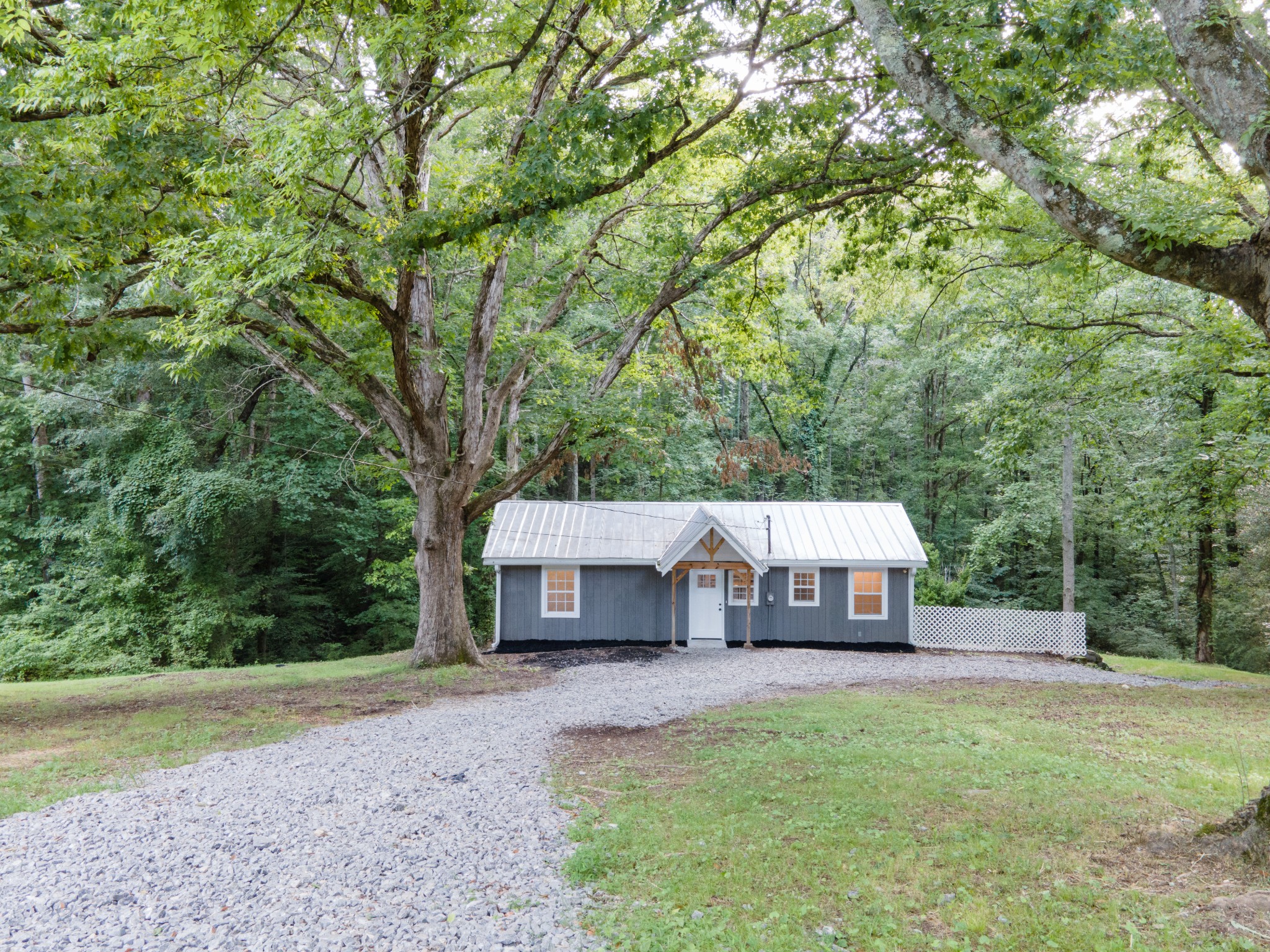 a front view of a house with a yard and trees