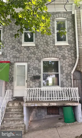 a view of a house with a small yard and wooden floor