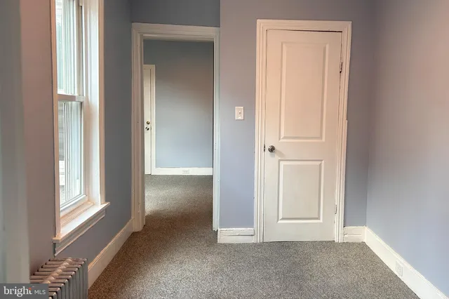 an empty room with windows and closet