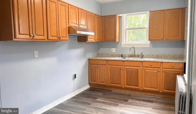 a kitchen with stainless steel appliances granite countertop a sink cabinets and a window