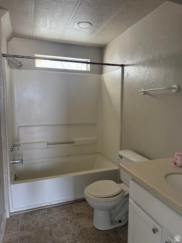 446 Riverside Drive, Unit 24 Wellington, UT 84542 - Photo 9 of 14 Full bathroom with a textured wall, vanity, shower / washtub combination, and a textured ceiling