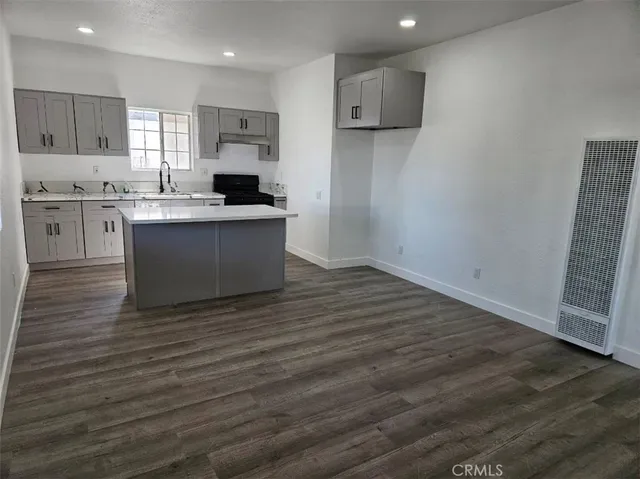 a view of empty room with wooden floor and windows