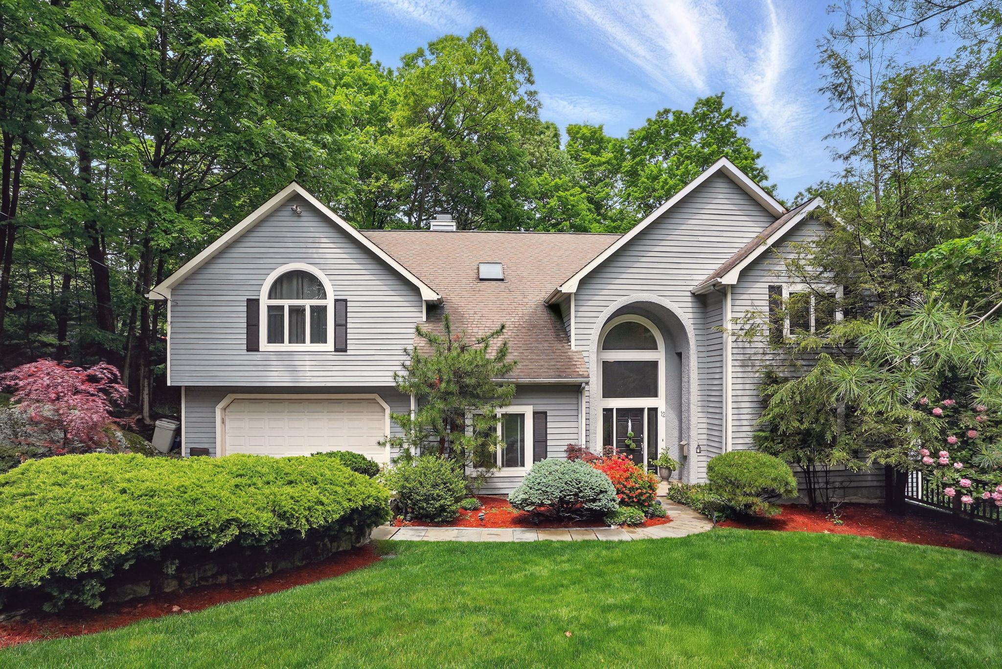 a front view of a house with a garden and plants