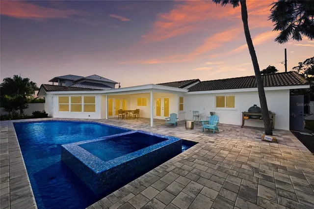 a swimming pool with outdoor seating and lake view