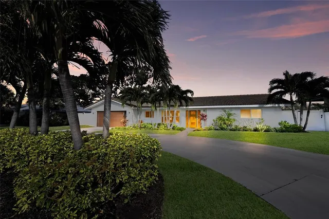 an aerial view of residential houses with outdoor space and trees
