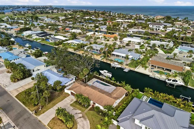 an aerial view of a house with a garden and lake view