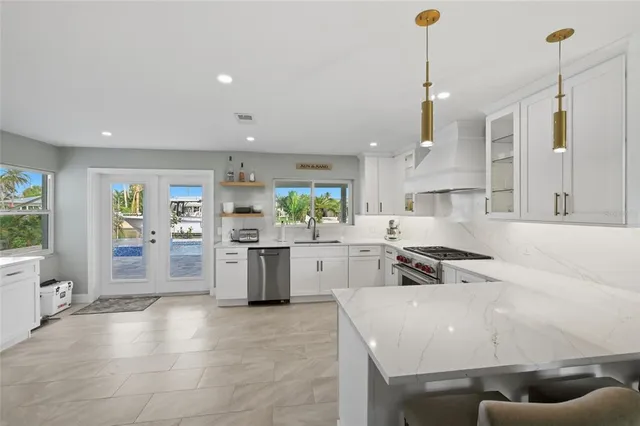 a large kitchen with kitchen island a stove a sink a counter space and a window
