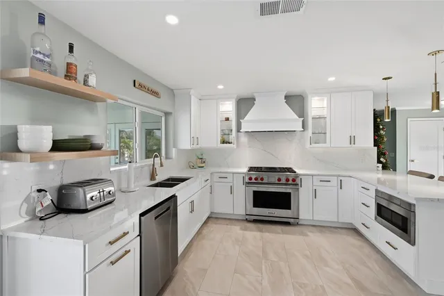 a kitchen with granite countertop stainless steel appliances a stove a sink and a refrigerator