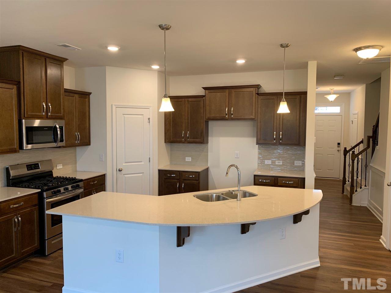 6154 Beale Loop, Unit 91 Raleigh, NC 27616 - Photo 3 of 12 a kitchen with stainless steel appliances a sink and a refrigerator
