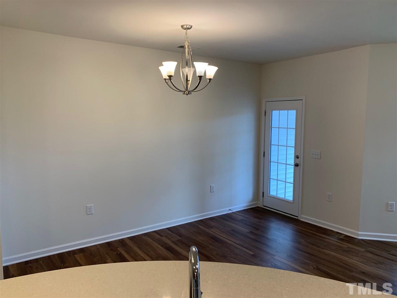 6154 Beale Loop, Unit 91 Raleigh, NC 27616 - Photo 5 of 12 a view of an empty room with wooden floor and a window