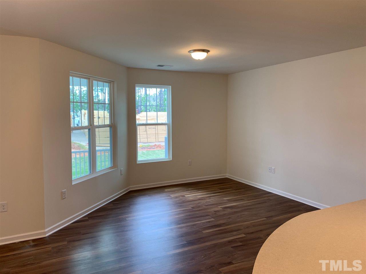 6154 Beale Loop, Unit 91 Raleigh, NC 27616 - Photo 6 of 12 an empty room with wooden floor and windows